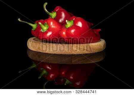 Group Of Three Whole Sweet Red Bell Pepper On Bamboo Plate Isolated On Black Glass