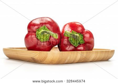 Group Of Two Whole Sweet Red Bell Pepper On Wooden Square Plate Isolated On White Background