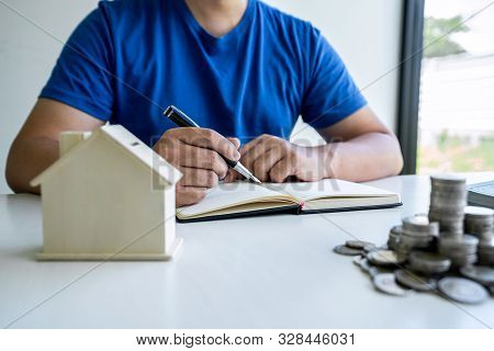 Man Writing Report To Planning Growing Saving To Strategy With Money Box For Future Plan Fund Of Tra