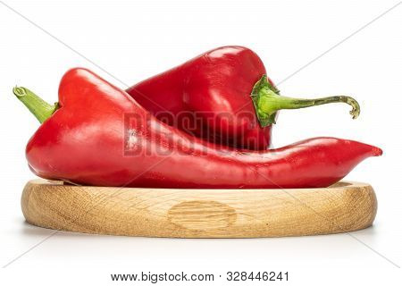 Group Of Two Whole Sweet Red Bell Pepper On Bamboo Plate Isolated On White Background