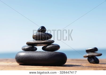 Stacks Of Stones On Wooden Pier Near Sea, Space For Text. Zen Concept