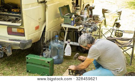 Encuentro Park, Chiapas, Mexico - April14th , 2018: Mechanic Changing Wheel In A Classic Camper Van 