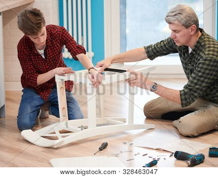 father and son work together. kitchen chair assembling