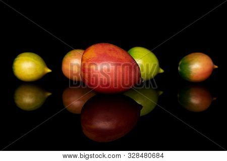 Group Of Five Whole Fresh Tomato De Barao Isolated On Black Glass
