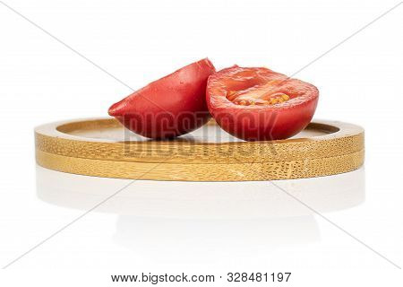 Group Of Two Halves Of Fresh Tomato De Barao On Round Bamboo Coaster Isolated On White Background