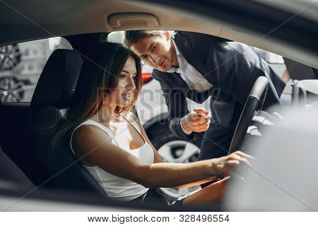 Stylish And Elegant Couple In A Car Salon