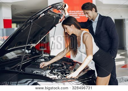 Stylish And Elegant Couple In A Car Salon