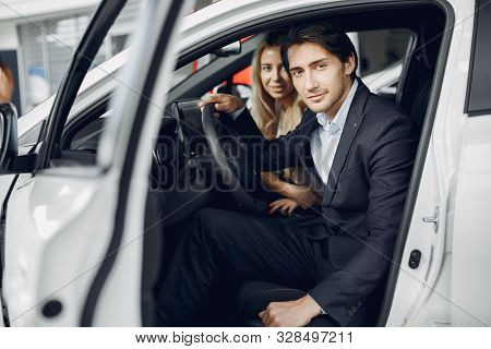 Stylish And Elegant Couple In A Car Salon