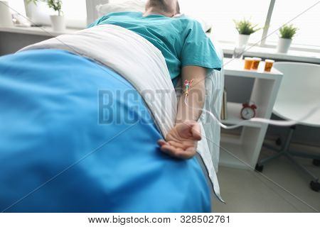 Fight For Life Concept. Hand Of A Young Man With A Dropper In Ward Of Medical Hospital. Lies After C