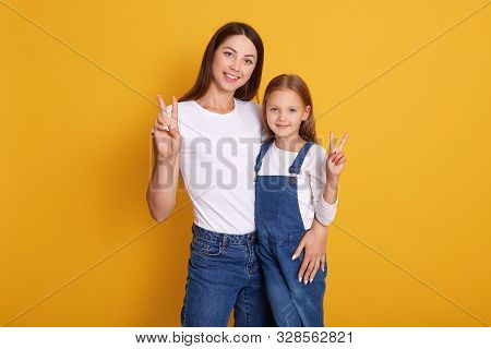 Close Up Portrait Of Happy Woman Showing Peace Sign With Her Charming Daughter, Woman Wearing White 