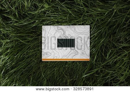 Notepad Is Lying On The Grass. There Is A Place For Your Text Or Logo. Layout Mockup
