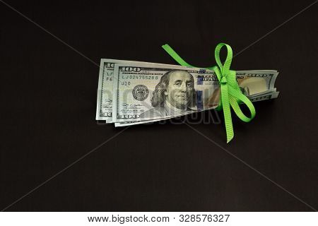 Four Banknotes Four Hundred Us Dollars On A Black Background Tied With A Green Ribbon