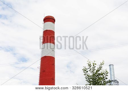Red White Chimney With Tree And Steel Tower On Blue Sky With Furry Clouds Scene