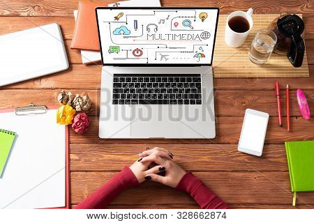 Multimedia Education Concept With Office Workspace. Flat Lay Wooden Desk With Laptop, Woman Hands An