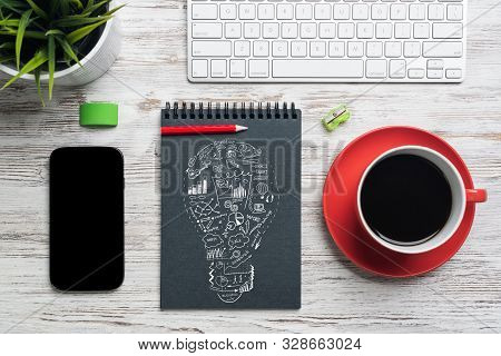 Flat Lay Wooden Desk With Computer Keyboard And Mouse, Mobile Phone And Spiral Notebook With Idea Li
