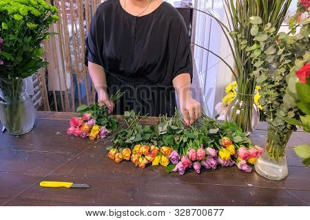 Floral Business Concept. Professional Woman Florist Creates Big Bunch From Colourful Roses In Flower