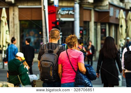 Old Couple Holding Their Hands And Walking In Old Town Bucharest, Romania, 2019