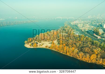 Autumn Landscape Of The Left Bank Of Kiev. Trees With Yellowed Leaves, The Dnieper Riverbed With Col