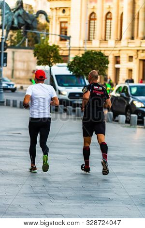 People Running On The Sidewalk Of Victoriei Way (calea Victoriei) In Downtown Bucharest, Romania, 20