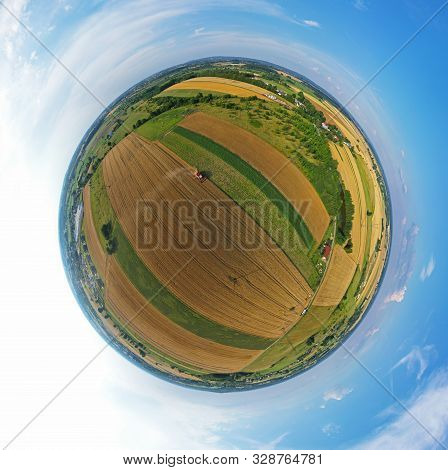 Aerial Drone 360 Degree Spherical Tiny Planet View On Red Harvester During Wheat Field Harvesting, C