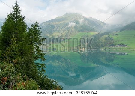 The Lake Vernagt-stausee (schnalstal, South Tyrol, Italy) On A Misty Morning In Summer. The Water Of