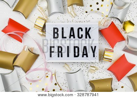 Black Friday Sale Text On White Lightbox, Golden Stars And Packaging Around On White Background