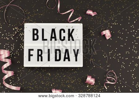 Black Friday Sale Text On White Lightbox, Golden Stars And Holiday Ribbon Around On Black Background