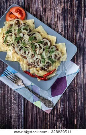 Beshbarmak Is A National Tatar Dish - Square Pasta With Boiled Meat And Onions. On Wooden Background
