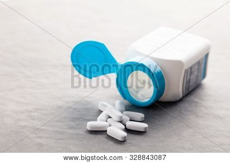 Pharmaceutical Medicine Tablets, Pills, Capsules, Drugs On Grey Background In White And Blue Plastic