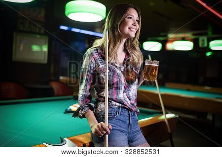 Young Smiling Girl Playing Billiard In Club