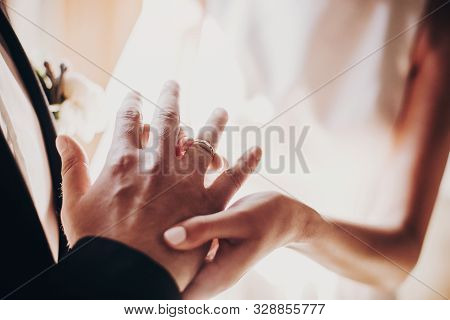 Wedding Couple Exchanging Wedding Rings During Holy Matrimony In Church. Bride And Groom Putting Gol
