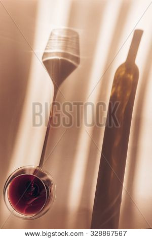 A Spectacular Long Shadow Falls From The Glass With Wine, Next To It Is The Shadow Of A Bottle Of Wi