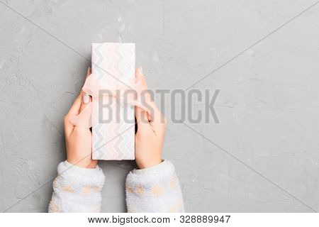Top View Woman Hands Holding Present Box With Colored Bow On Gray Cement Wooden Background With Copy