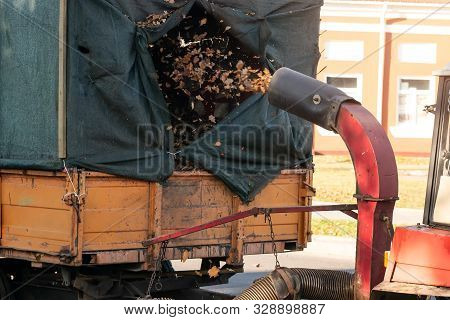 Heavy Industrial Vaccuum Loader Loading Fallen Leaves And Junk Into Truck Body. Municipal Services C