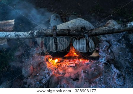 Top View Of Two Metal Pots Above The Fire In The Woods. Cooking Dinner In A Travel.