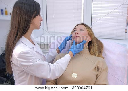 Woman Patient Is Consulted By A Cosmetologist Before Rejuvenating Injections Into The Face. Young Do