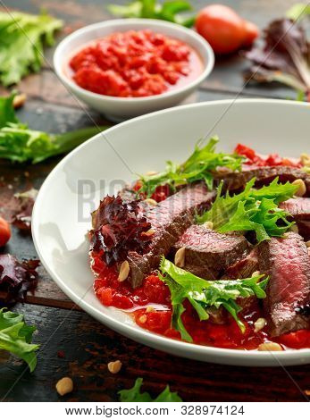 Beef Steak With Romesco Sauce, Nuts And Vegetables On White Plate