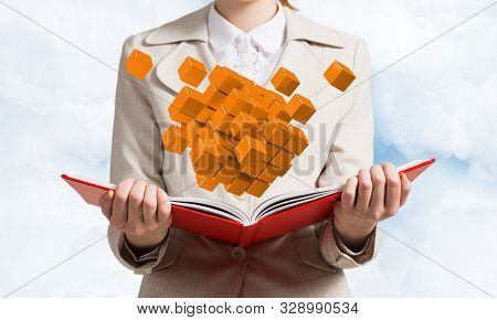 Young Woman Holding Open Book With Flying 3d Orange Cubes. Hi-tech Concept With Virtual Reality Elem