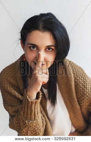 Silence Gesture. Portrait Of A Young Cute Woman In Sweater Saying Please Keep Calm Sign Over White B