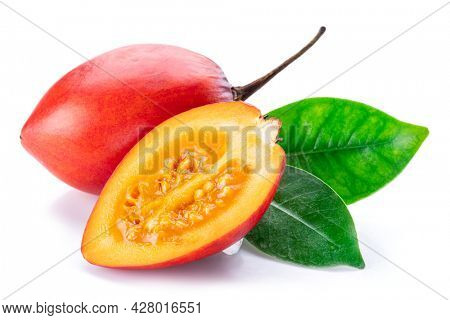 Ripe tamarillo fruits with slices and tamarillo leaves isolated on a white background.