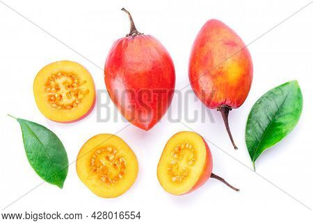 Ripe tamarillo fruits with slices and tamarillo leaves isolated on a white background.