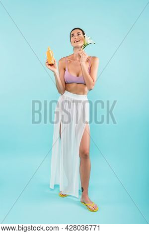 Happy Woman With Lily Flower And Sunblock Posing In White Pareo On Blue