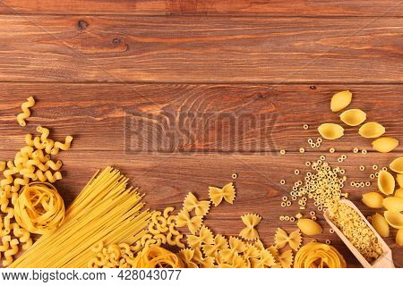 Different Types Of Raw Pasta Close-up On A Colored Background.