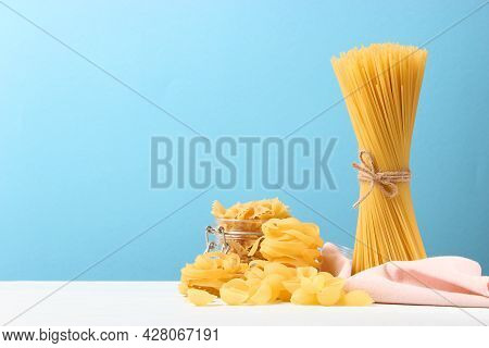 Different Types Of Raw Pasta Close-up On A Colored Background.