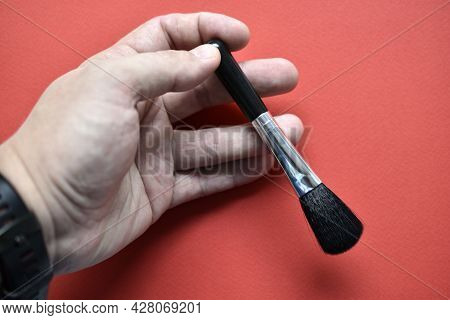 Brush For Cleaning Optics On A Red Background