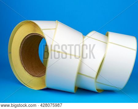 White Roll Of Labels For Thermal Perforation On A Blue Background. Babina Of Self-adhesive Stickers.