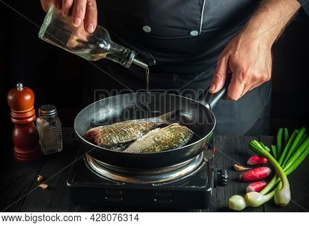 Professional Chef Prepares Fresh Fish In A Pan With Oil. Preparation For Cooking Fish Food. Working 