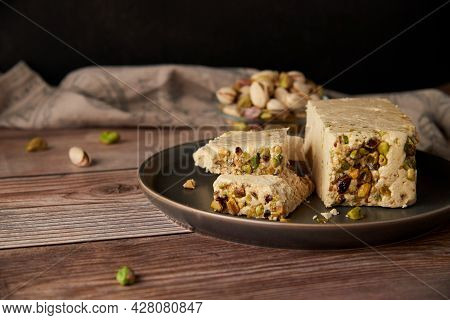 Organic Halva With Pistachios On A Wooden Surface. Traditional Middle Eastern Sweets. Jewish, turkis