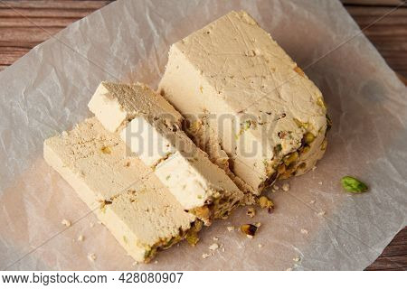 Organic Halva With Pistachios On A Wooden Surface. Traditional Middle Eastern Sweets. Jewish, turkis