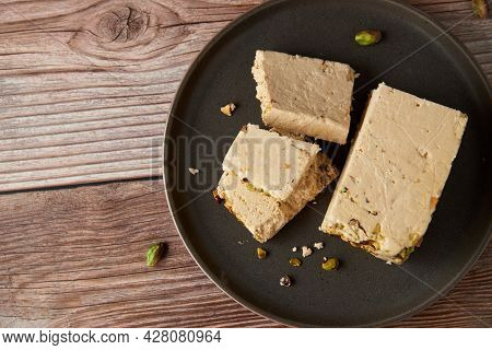 Organic Halva With Pistachios On A Wooden Surface. Traditional Middle Eastern Sweets. Jewish, turkis